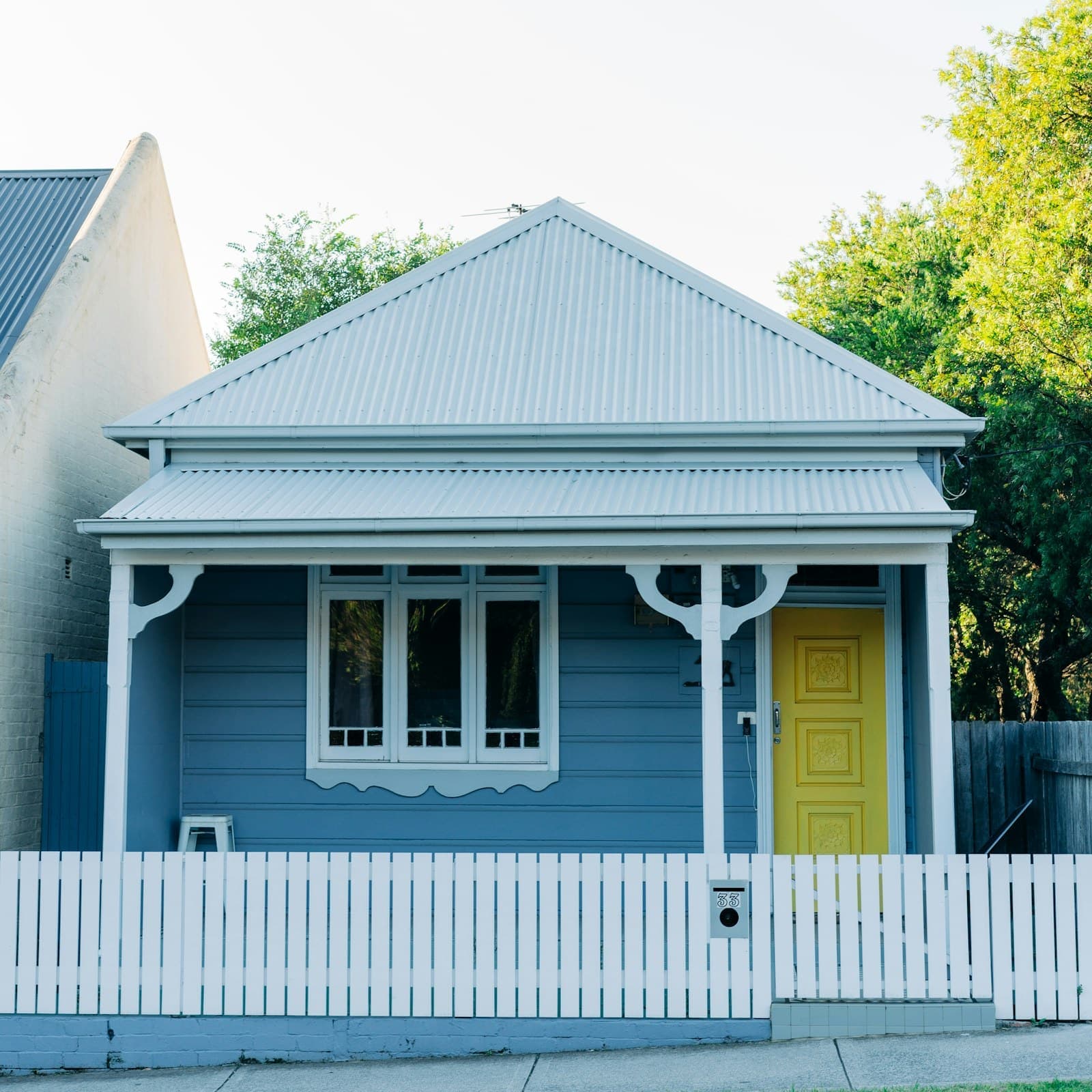 Weatherboard cottage with a bullnose verandah and a yellow front door