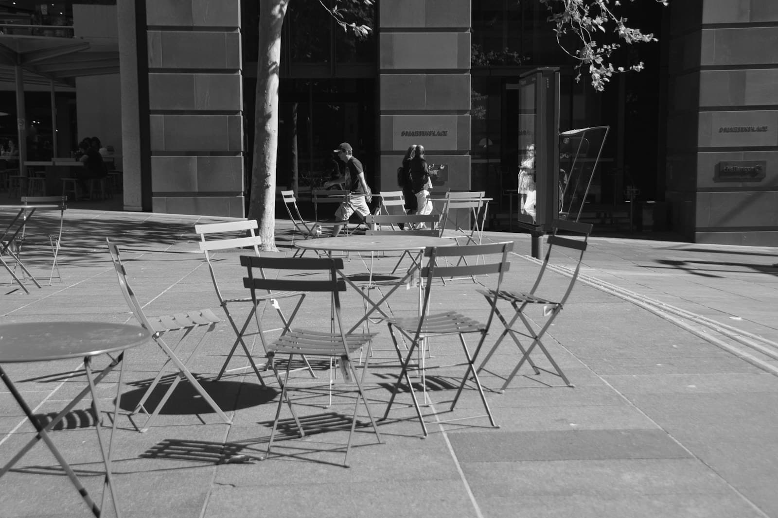 Cafe tables on a shaded footpath